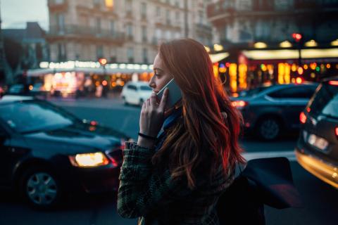 Mujer hablando por teléfono mientras anda por la calle