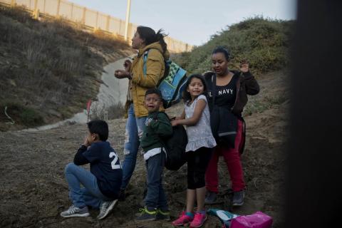 Honduran migrants surrender to the US Border Patrol after crossing the border wall into the US.