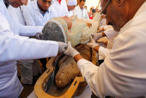 Archaeologists remove the cover of an ancient painted coffin discovered at al-Asasif Necropolis in the Vally of Kings in Luxor, Egypt, October 19, 2019.