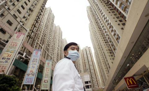 A security guard wears a mask at Amoy Gardens housing estate in Kowloon bay, Hong Kong, where a block was quarantined to protect against a SARS outbreak, April 1, 2003.