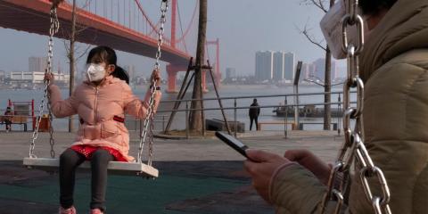 Una niña juega en un columpio cerca del puente del río Yingwuzhou Yangtze en Wuhan.