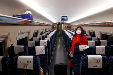 Una pasajera con una máscara en un tren vacío en el interior de China Una pasajera con una máscara en un tren vacío en el interior de China