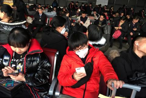Passengers wear masks in the waiting area for a train to Wuhan at the Beijing West Railway Station on January 20, 2020.