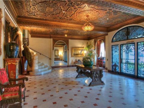 The "Under the Tuscan Sun" vibe doesn't stop there. An ornate entryway with carved wood ceilings and a sweeping marble staircase helps whisk residents away from city life.