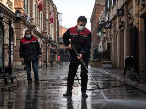 Cleaners wash a street in the quarantined city of Wuhan with a high-pressure water gun on February 3, 2020. Cleaners wash a street in the quarantined city of Wuhan with a high-pressure water gun on February 3, 2020.