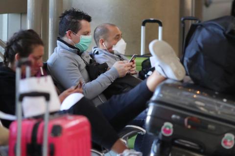 People wear masks at the international terminal at LAX airport in Los Angeles, California on March 11, 2020. People wear masks at the international terminal at LAX airport in Los Angeles, California on March 11, 2020.