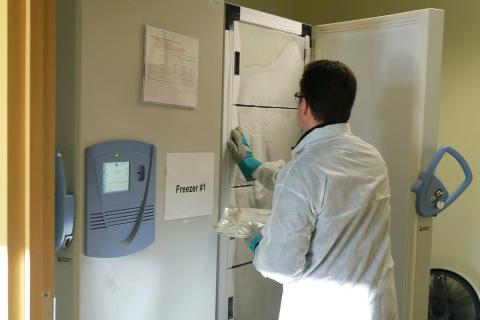 Witte takes a package of the vaccine out of a freezer.