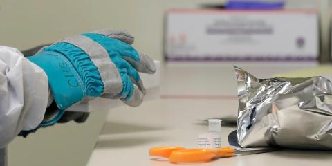 Witte opens a frozen package of the trial vaccine for COVID-19.
