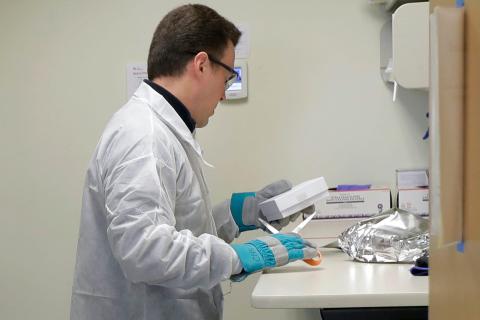 Witte opens a package that contains the trial vaccine for COVID-19.