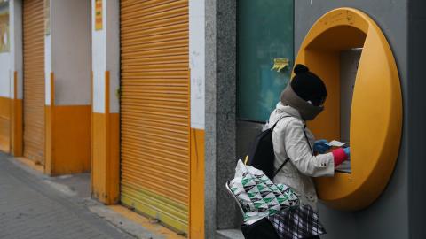 Una mujer usa un cajero automático durante la pandemia de coronavirus en Madrid.