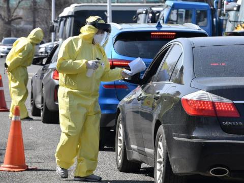 Medical workers wearing guide drivers at a drive-thru coronavirus testing facility in Goyang, South Korea, on February 29.