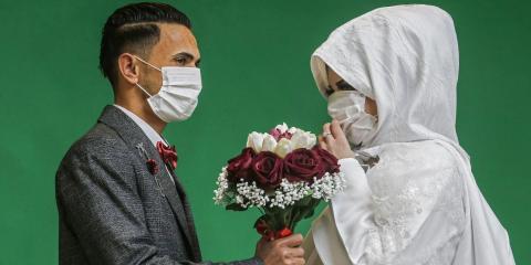 Palestinian groom Mohamed abu Daga and his bride Israa wear protective masks amid the COVID-19 epidemic, during a photoshoot at a studio before their wedding ceremony. Palestinian groom Mohamed abu Daga and his bride Israa wear protective masks amid the COVID-19 epidemic, during a photoshoot at a studio before their wedding ceremony.
