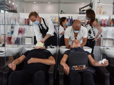 Women are separated by dividers as they have their hair washed at Bella Rinova in Houston, Texas on May 8, 2020.