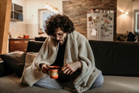 Hombre midiendo la temperatura con un termómetro para saber si tiene fiebre.