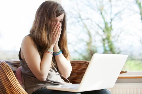 Chica preocupada mirando el ordenador Chica preocupada mirando el ordenador