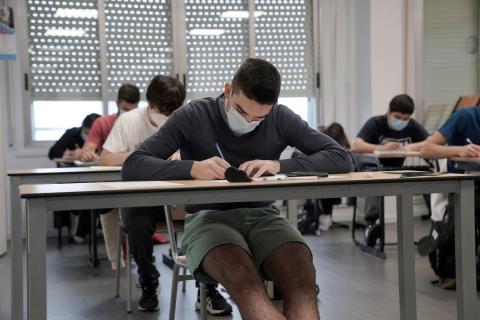 Chico tomando apuntes en clase. Chico tomando apuntes en clase.