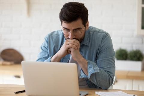 Hombre mira preocupado su ordenador