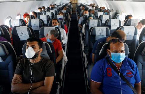 Pasajeros llevan mascarillas en un avión en el Aeropuerto Internacional de Sharm el-Sheij, en Egipto.