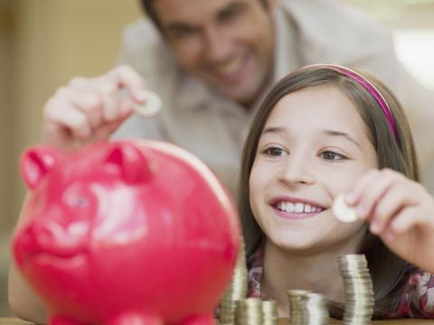 Niña metiendo dinero en la hucha
