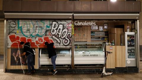 2 employees of an ice cream shop in Barcelona close the door before curfew