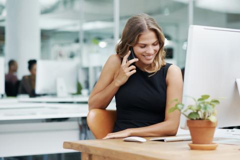 Una mujer habla por teléfono en la oficina.