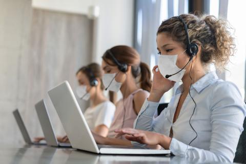 Tres mujeres atienden el teléfono.