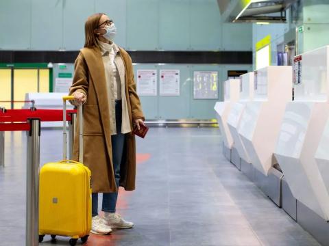 A woman wears a jacket in an airport.