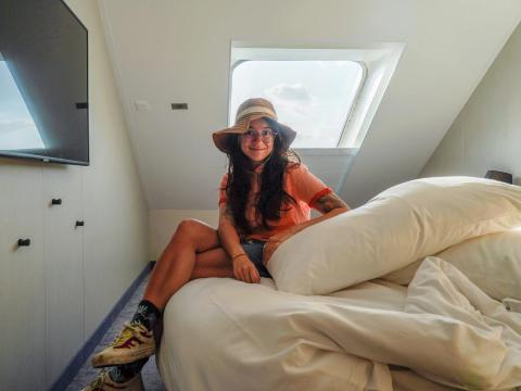 the author sits on the bed on the world's largest cruise ship