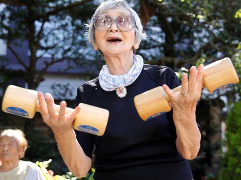 Elderly and middle-aged people exercise with wooden dumbbells during a health promotion event to mark Japan's "Respect for the Aged Day" at a temple in Tokyo's Sugamo district, an area popular among the Japanese elderly, Japan, Elderly and middle-aged people exercise with wooden dumbbells during a health promotion event to mark Japan's "Respect for the Aged Day" at a temple in Tokyo's Sugamo district, an area popular among the Japanese elderly, Japan,