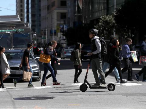 A user riding a Spin scooter on April 17 in San Francisco. A user riding a Spin scooter on April 17 in San Francisco.