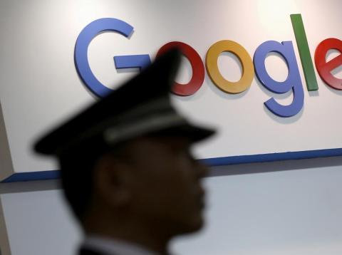 A security guard keeps watch as he walks past a logo of Google in Shanghai, China. A security guard keeps watch as he walks past a logo of Google in Shanghai, China.