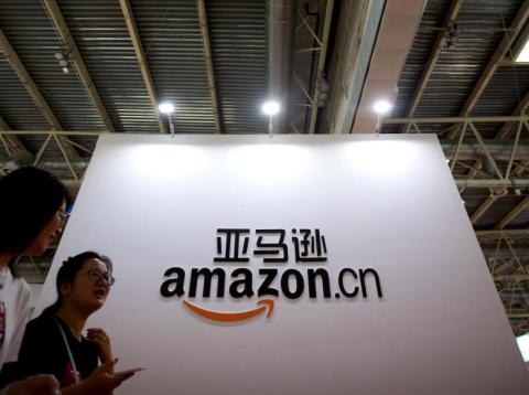 Visitors walk past a logo for Amazon China at the Beijing International Book Fair in Beijing on Aug. 23, 2017. Visitors walk past a logo for Amazon China at the Beijing International Book Fair in Beijing on Aug. 23, 2017.
