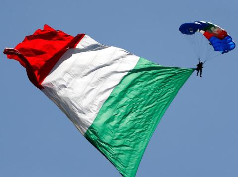 An Italian Army parachutist hoisting the Italian flag during the Republic Day military parade in Rome. An Italian Army parachutist hoisting the Italian flag during the Republic Day military parade in Rome.