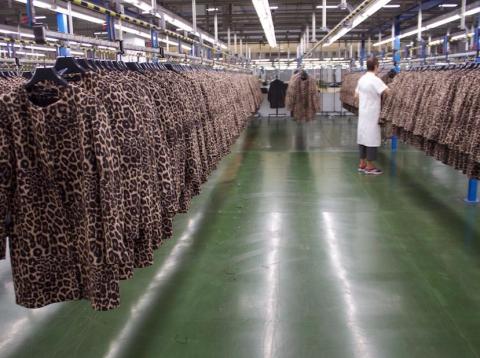 Rows of Zara coats are checked by hand. Rows of Zara coats are checked by hand.