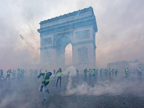 Teargas surrounds protesters as they clash with riot police during a 'Yellow Vest' demonstration near the Arc de Triomphe in Paris on Saturday. Teargas surrounds protesters as they clash with riot police during a 'Yellow Vest' demonstration near the Arc de Triomphe in Paris on Saturday.