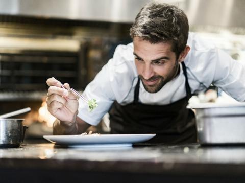 Un cocinero prepara un plato Un cocinero prepara un plato