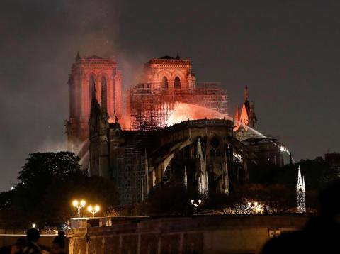 Firefighters douse flames from the burning Notre-Dame Cathedral on Monday. Firefighters douse flames from the burning Notre-Dame Cathedral on Monday.