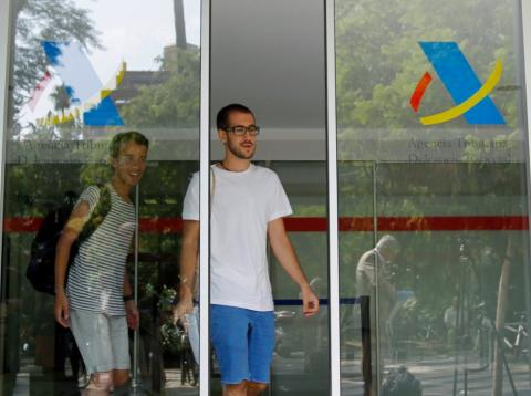 Dos jóvenes salen de una oficina de la Agencia Tributaria Dos jóvenes salen de una oficina de la Agencia Tributaria