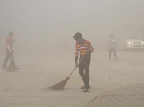 Trabajadores indios usan escobas para barrer el polvo en la niebla matutina en el Gran Noida, cerca de Nueva Delhi, India, el 10 de noviembre de 2017. Trabajadores indios usan escobas para barrer el polvo en la niebla matutina en el Gran Noida, cerca de Nueva Delhi, India, el 10 de noviembre de 2017.