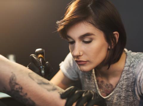 Chica haciendo un tatuaje Chica haciendo un tatuaje