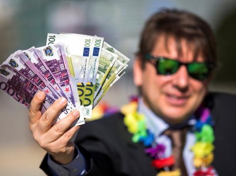 Un hombre sostiene un fajo de billetes de euro Un hombre sostiene un fajo de billetes de euro