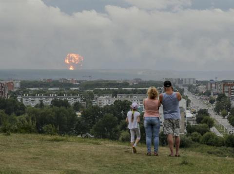 A family watches explosions at a military ammunition depot near Achinsk, Russia, on August 5. Russian officials say powerful explosions at the depot left 12 people injured and one missing and forced over 16,500 people to leave A family watches explosions at a military ammunition depot near Achinsk, Russia, on August 5. Russian officials say powerful explosions at the depot left 12 people injured and one missing and forced over 16,500 people to leave
