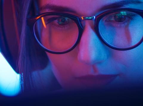 Mujer jugando a videojuegos Una chica con gafas jugando a videojuegos