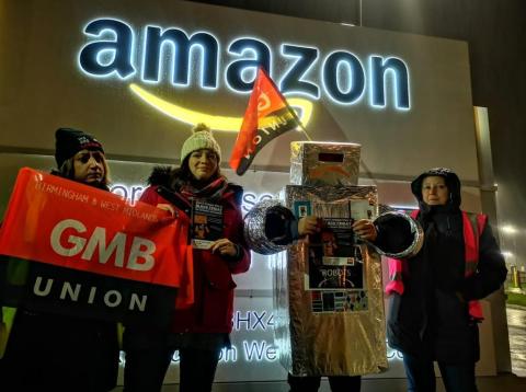Union members protest outside an Amazon warehouse in the UK. Union members protest outside an Amazon warehouse in the UK.