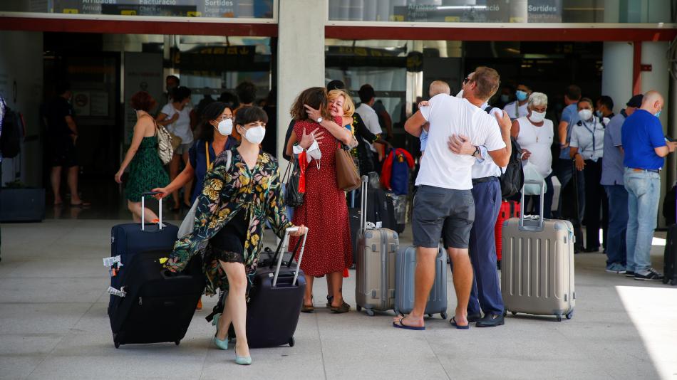 Personas reencontrándose en las puertas de un aeropuerto.