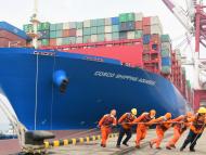 Estibadores del puerto de Qingdao ayudan en el atraque de un carguero