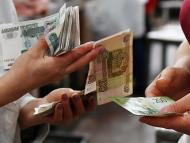 Unos vendedores cuentan billetes de rublos rusos en un mercado de Omsk, Rusia
