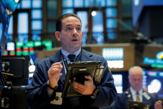 Trader sorprendido mirando a las pantallas en Wall Street