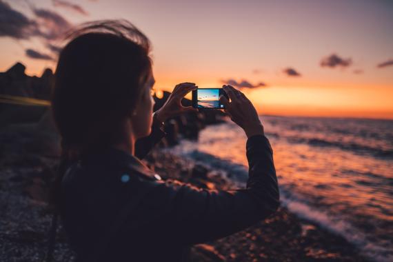 Una mujer haciendo una foto al horizonte con un teléfono
