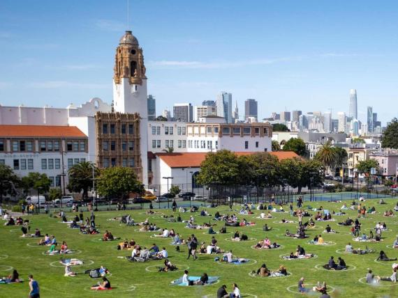 La gente se reúne en círculos pintados en la hierba para fomentar el distanciamiento social en el Dolores Park en San Francisco, California.